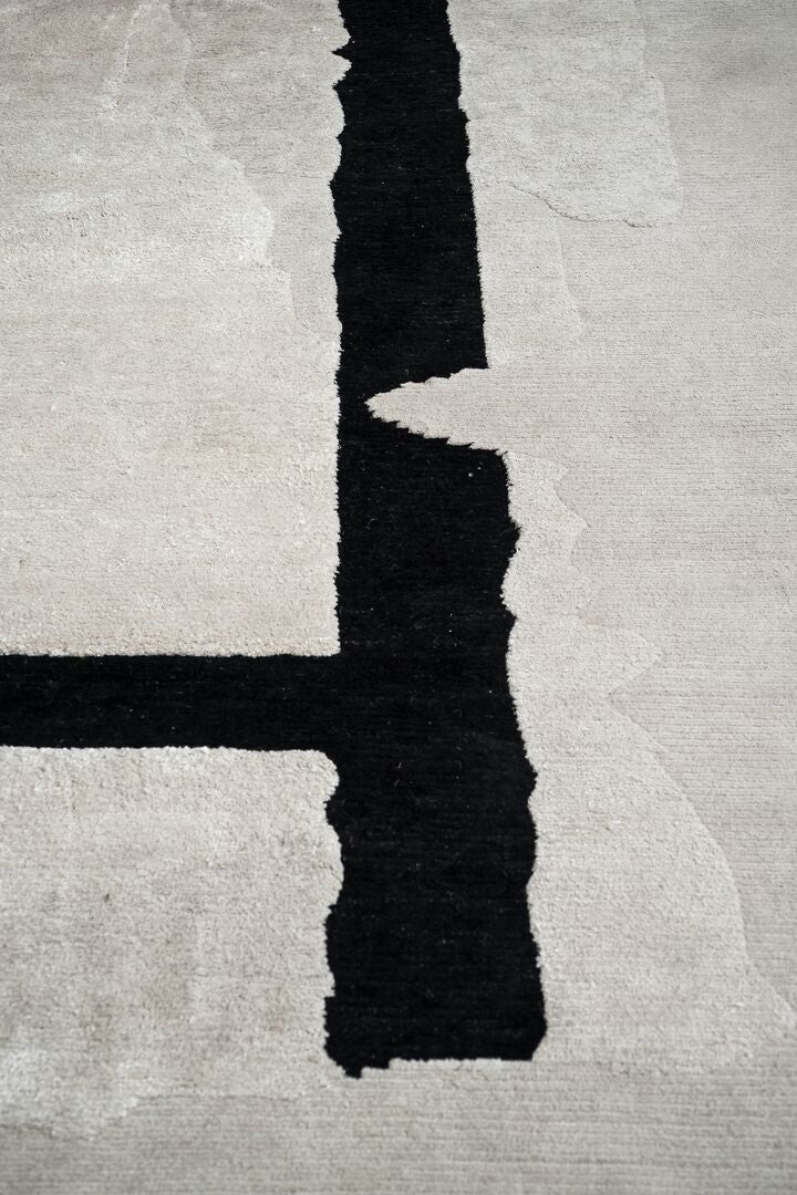 Close-up of a textured rug with black and white abstract shapes