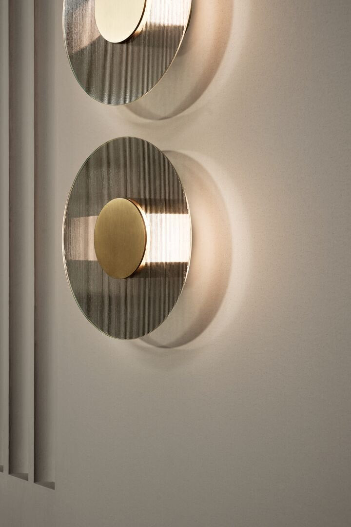 Decorative wall light fixture with circular design in brass and glass
