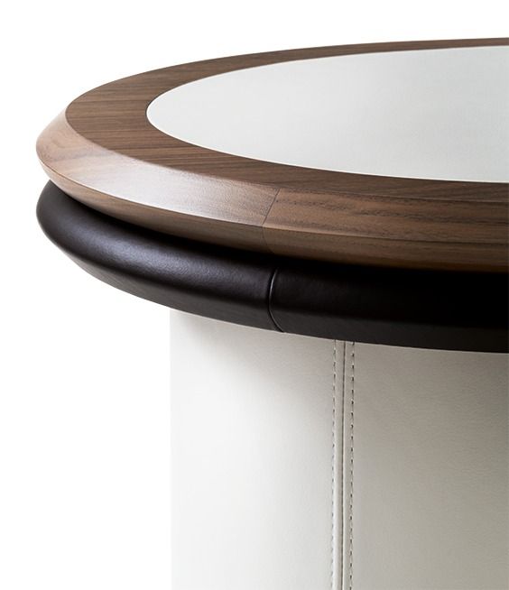 Close-up of a round wooden table with a white surface on a white background