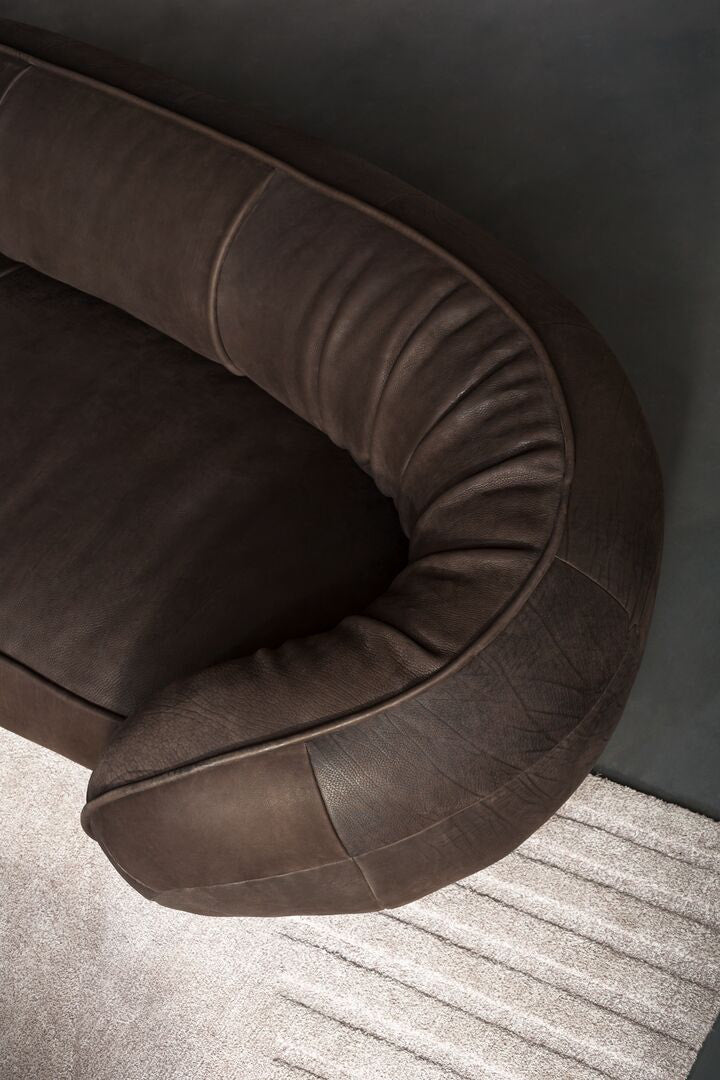 Curved modern leather sofa with piping 