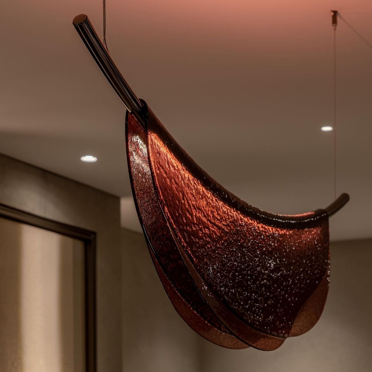 Decorative modern hanging lamp with a brown and black design in a room setting.