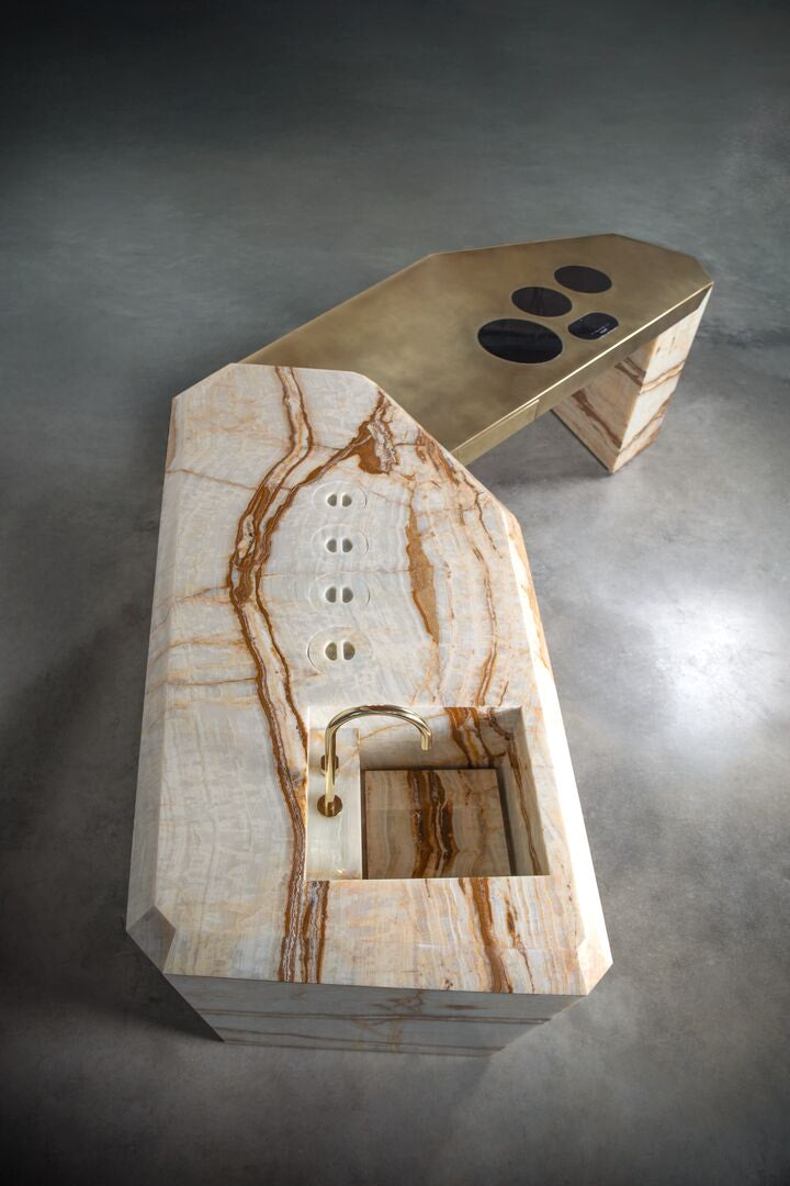 Marble and brass kitchen island with solid sink and brass tap and recessed hob