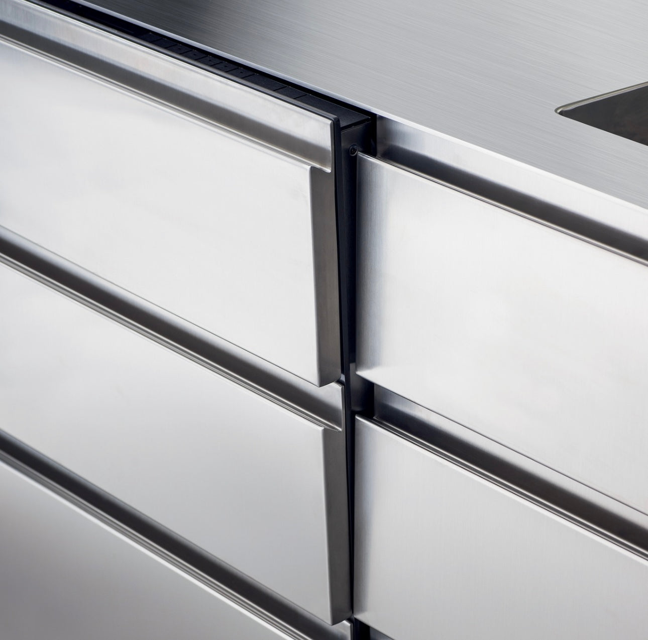 Close-up of stainless steel kitchen cabinets with a focus on the joinery.