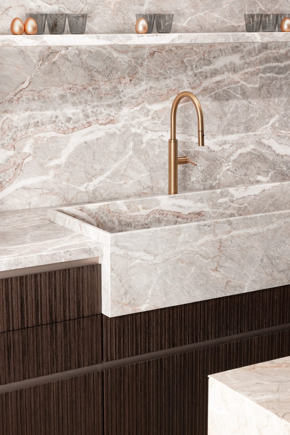 Marble countertop with a sink and bronze faucet against a stone backsplash and ribbed wood cabinet doors