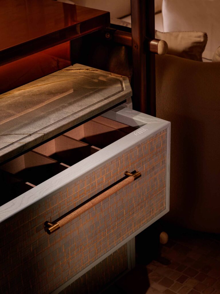 Drawer with a wooden top and metallic handle in a warm-toned interior setting