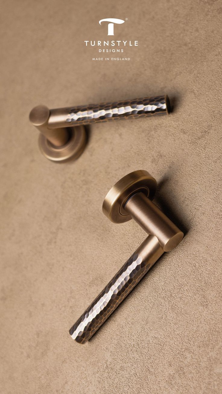 Brass door handles on a beige background with 'Turnstyle Designs' branding.